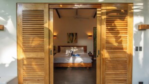 Un dormitorio con cama, ventilador de techo y una obra de arte en la pared.