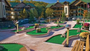 Un resort con edifici a più piani, un cortile curato con prati verdi e vialetti, e un'asta con la bandiera americana.