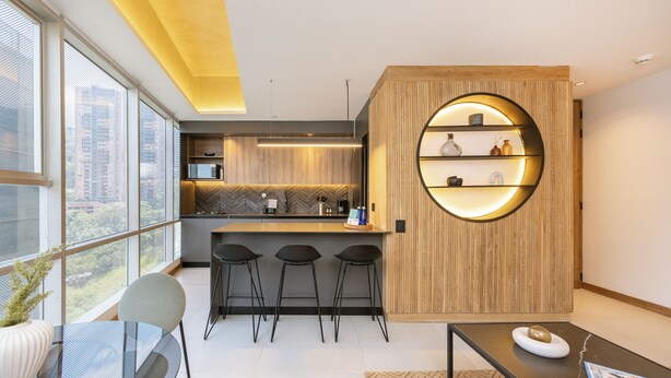 Eine moderne Küche mit Bar, großen Fenstern und einem runden Regalsystem.