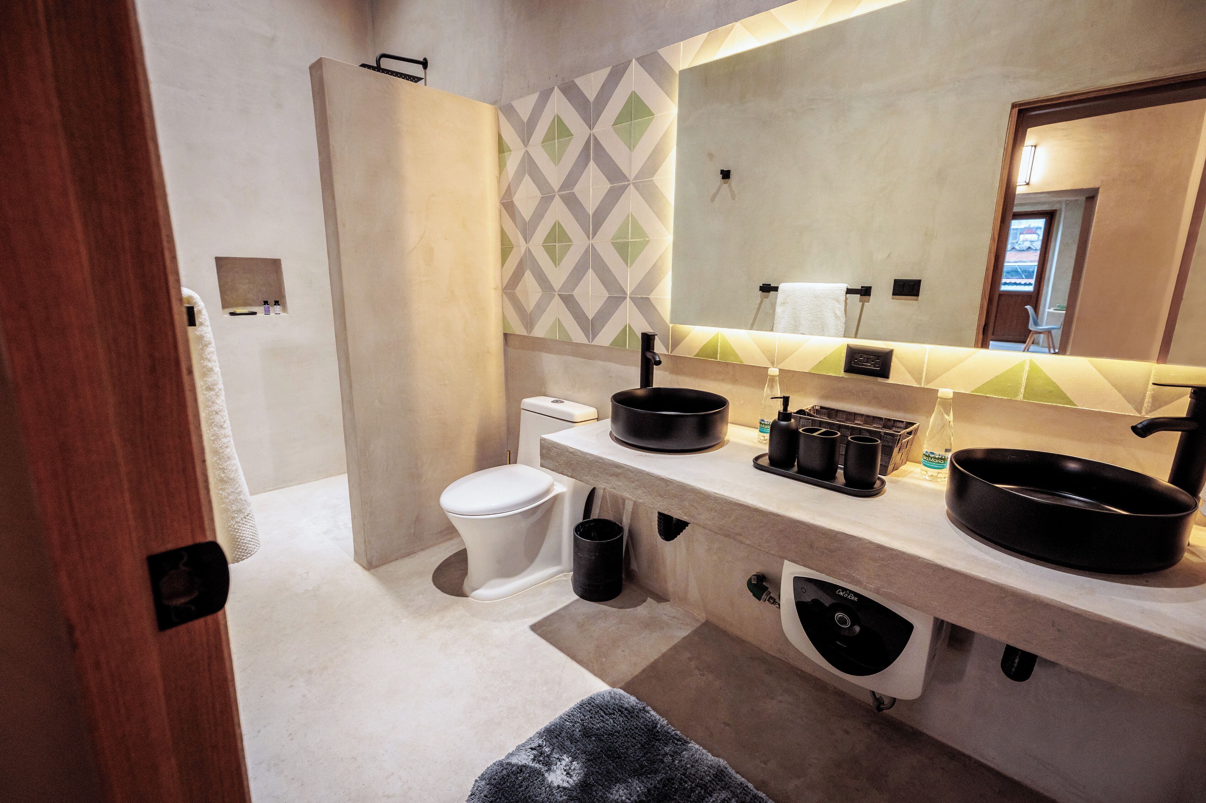 A modern bathroom with a toilet, sink, and mirror.