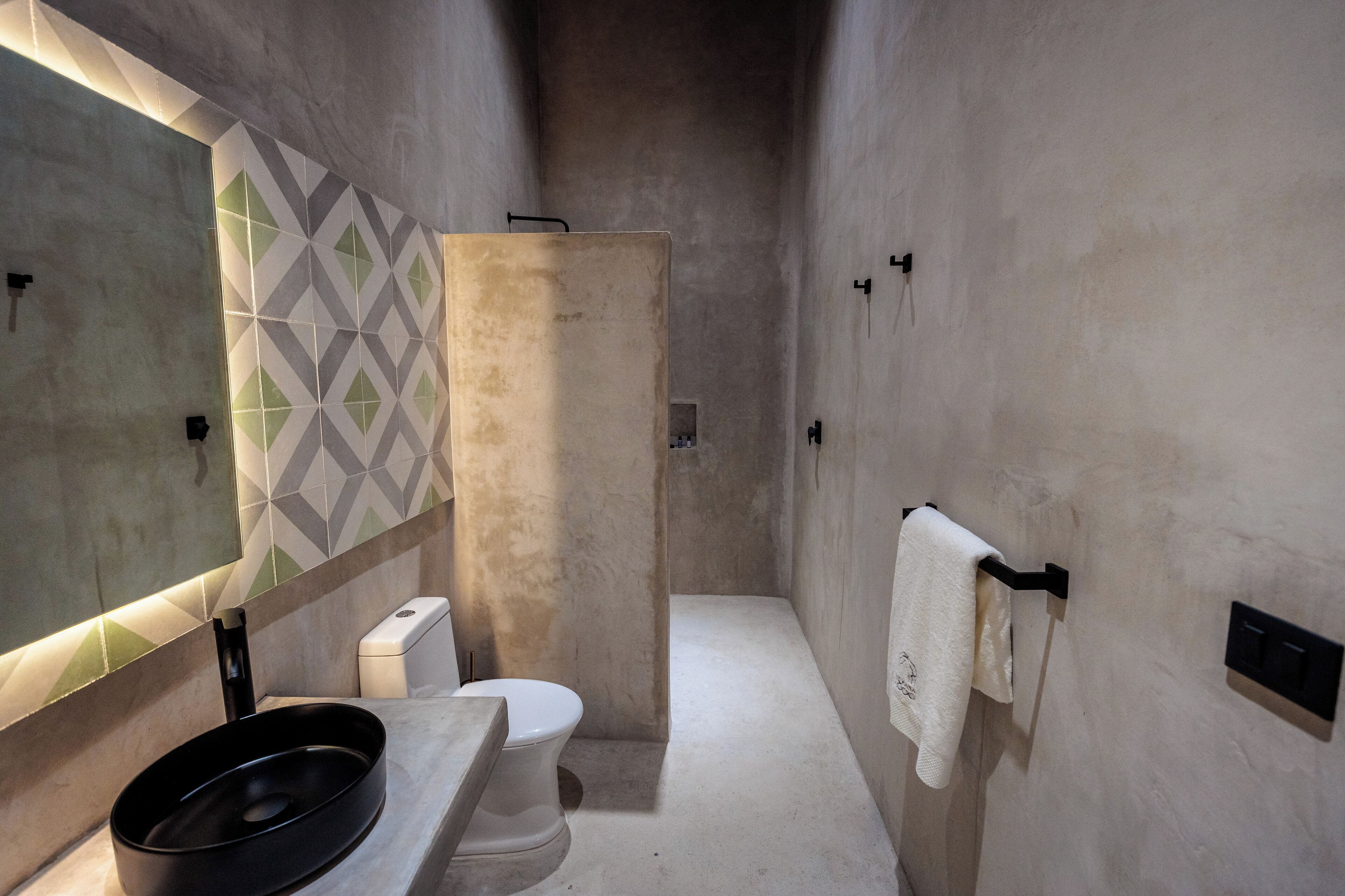 Une salle de bain moderne équipée de toilettes, d’un lavabo et d’une douche.