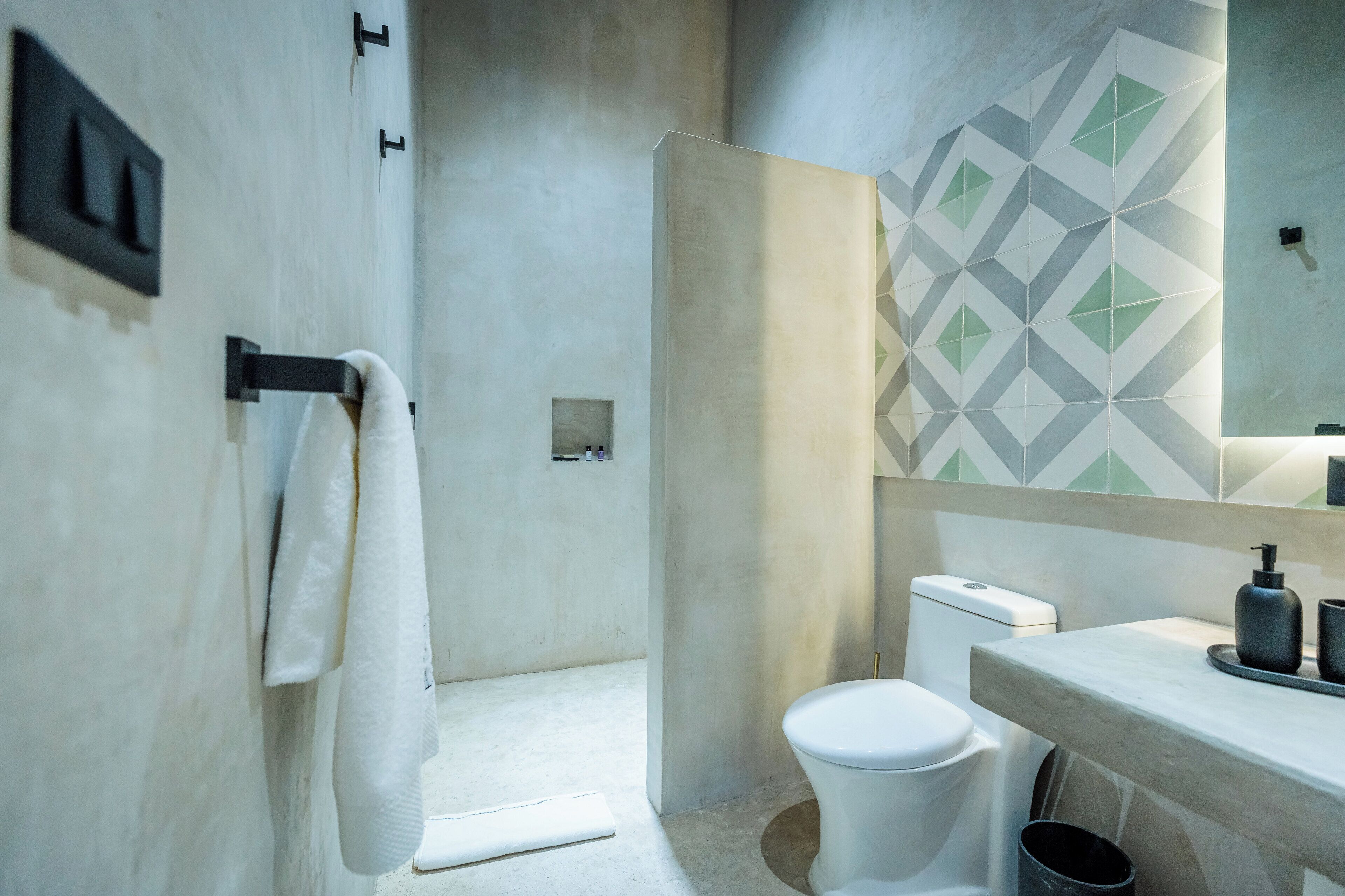 A modern bathroom with a toilet, sink, and towel rack.