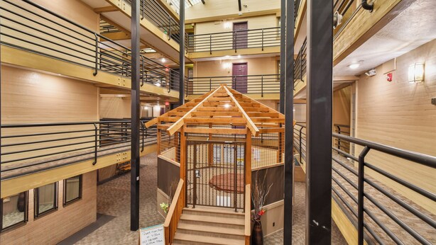 A multi-level indoor space with a central wooden structure resembling a gazebo, surrounded by metal railings and stairs. - New Claim by Park City Vacations (Park City)