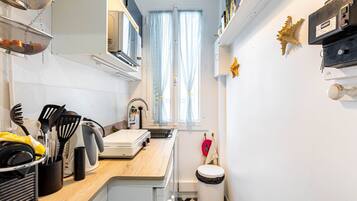A compact kitchen with a sink, stove, and various utensils.