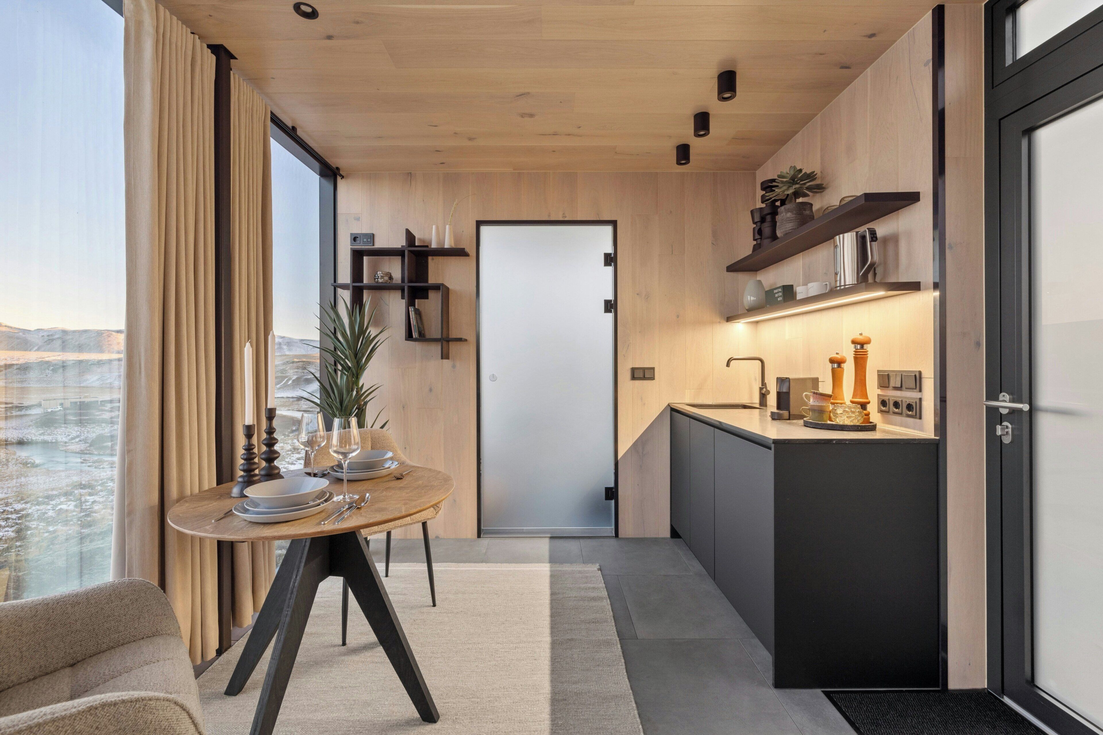 Eine moderne Küche mit Holztischplatte, Backofen und einer kleinen Kochinsel mit Spüle.