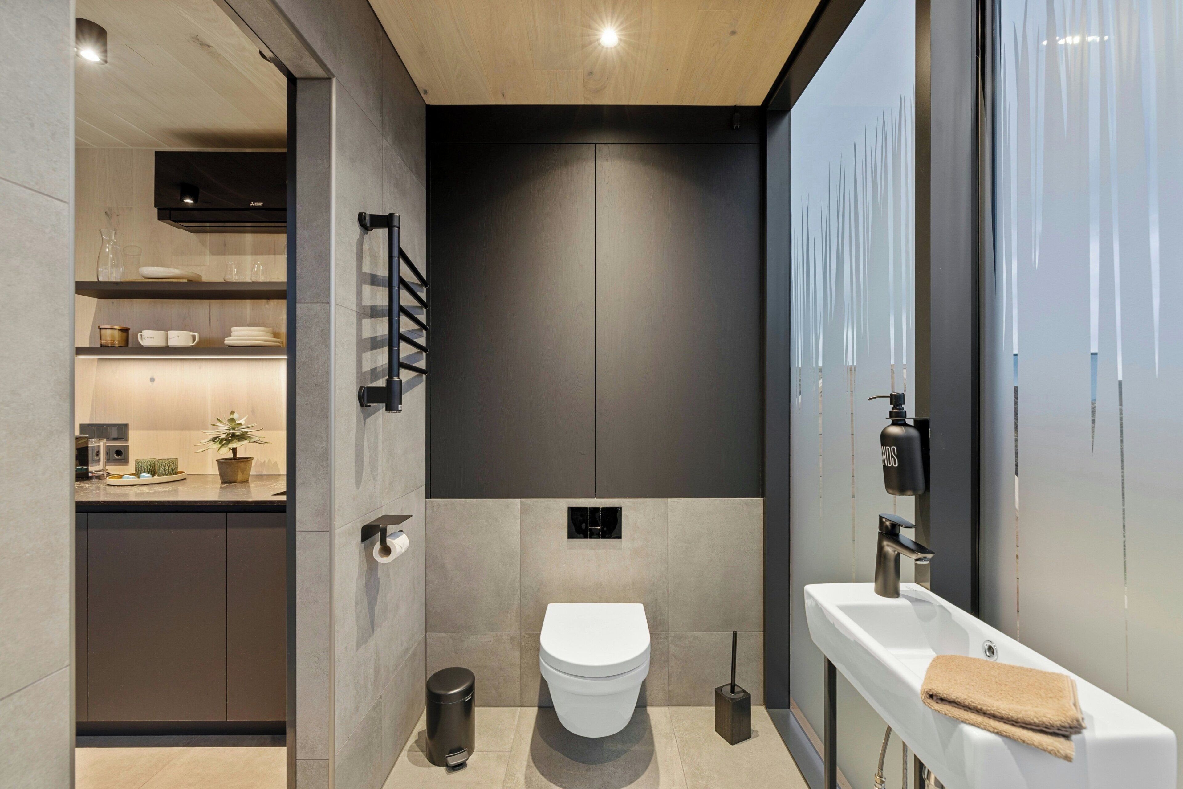 A modern bathroom with a toilet, sink, and shower area.