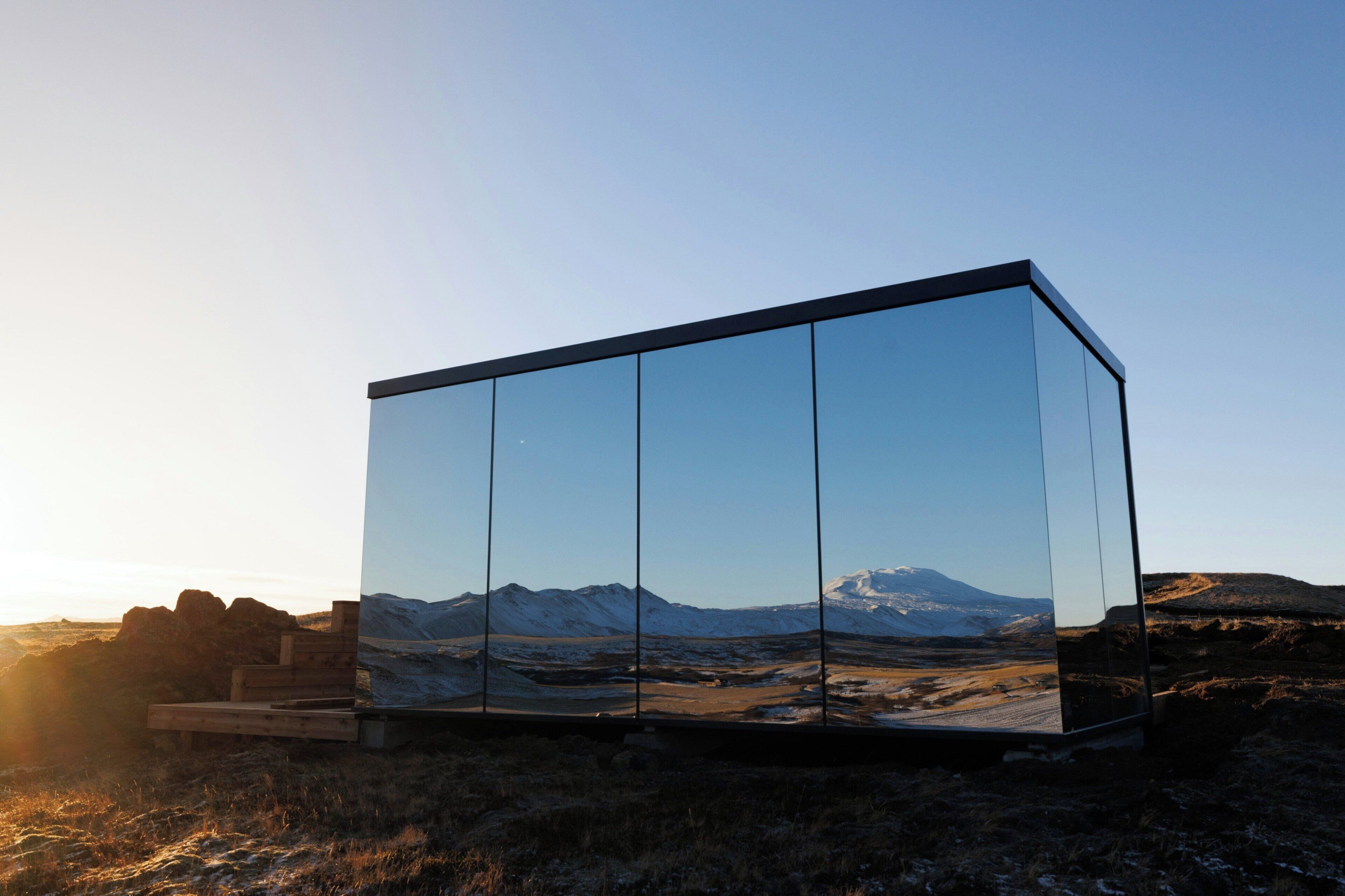 Un edificio moderno de cristal con vistas despejadas a un paisaje montañoso.