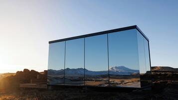Un edificio moderno de cristal con vistas despejadas a un paisaje montañoso.