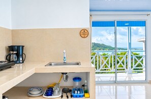 A kitchen with a coffee maker, sink, and various utensils. - SHAMAR LODGE  (Providencia)