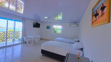 Quarto de hotel com uma cama grande, uma escrivaninha, uma cadeira, uma televisão e um quadro.
