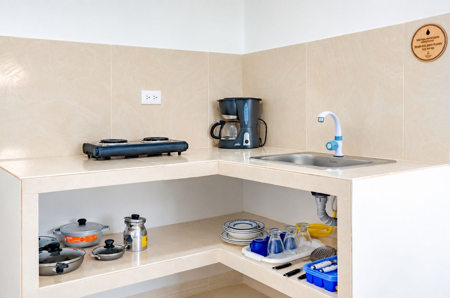 Una cucina con piano cottura a gas, macchina da caffè, lavello e diversi utensili da cucina.