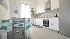 A modern kitchen with white cabinets, a built-in oven, and a refrigerator.