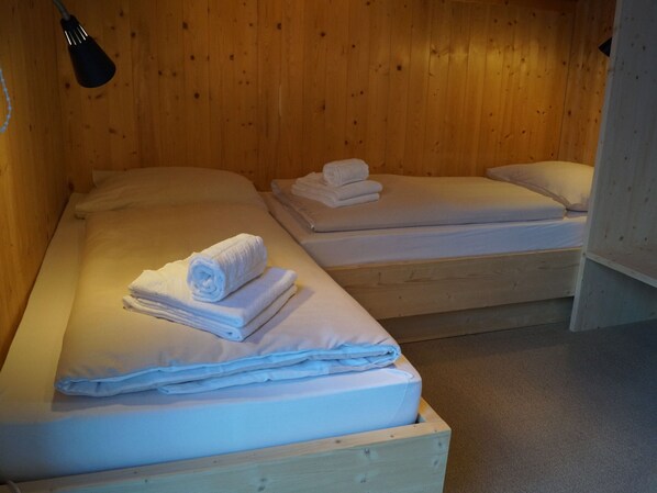 Two wooden bunk beds with white bedding and towels neatly folded on top. - Dreamy Chalet on the Slopes (Sankt Georgen am Kreischberg)