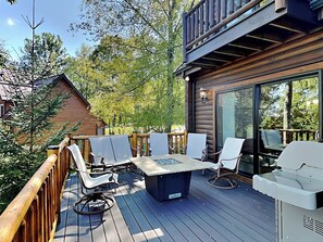 A wooden deck with outdoor furniture, including a table and chairs, and a grill. - Magnificent Mountain Lodge by Taylor Made Deep Creek (McHenry)
