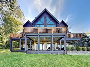Ein geräumiges, modernes Haus mit einem markanten Balkon, einer Veranda und einer Stein-Fassade.