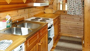 Une cuisine avec des meubles de rangement en bois, un évier en acier inoxydable, une cuisinière et un lave-vaisselle.