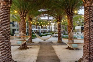 Ein Resort mit Palmen, Hängematten und Lichterketten.
