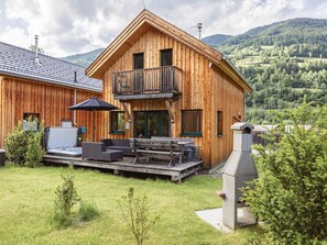 A wooden cabin with a balcony, outdoor seating, and a grill area. - Exclusive Chalet With Whirlpool (Sankt Georgen am Kreischberg)