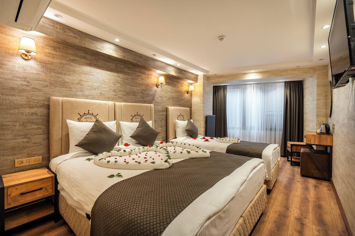 A hotel room with a large bed, bedside tables, a desk, and a TV.