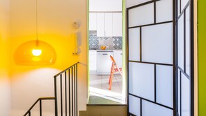 A staircase leading to a kitchen with white cabinets and a patterned backsplash. - Stylish in Spanish Quarter by Wonderful Italy (Naples)