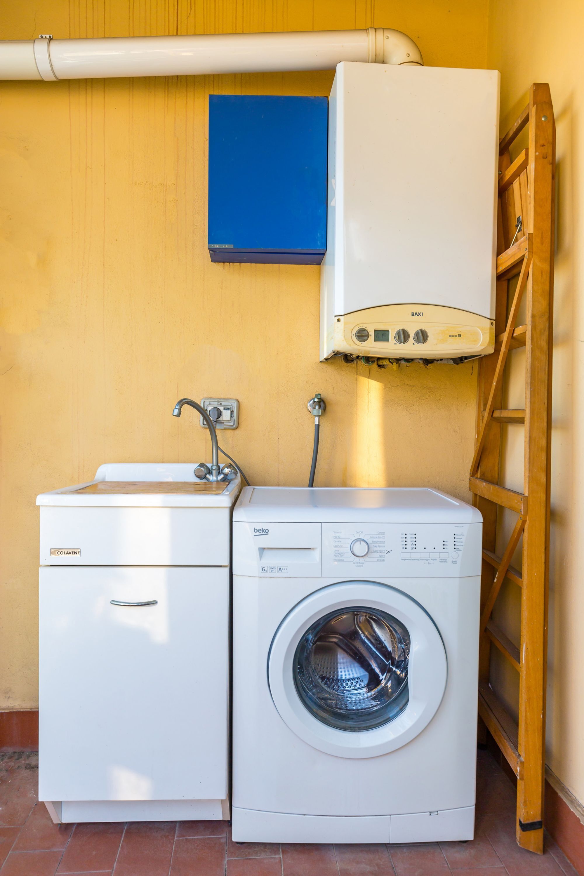 A compact laundry area with a washing machine, a dryer, and a sink.