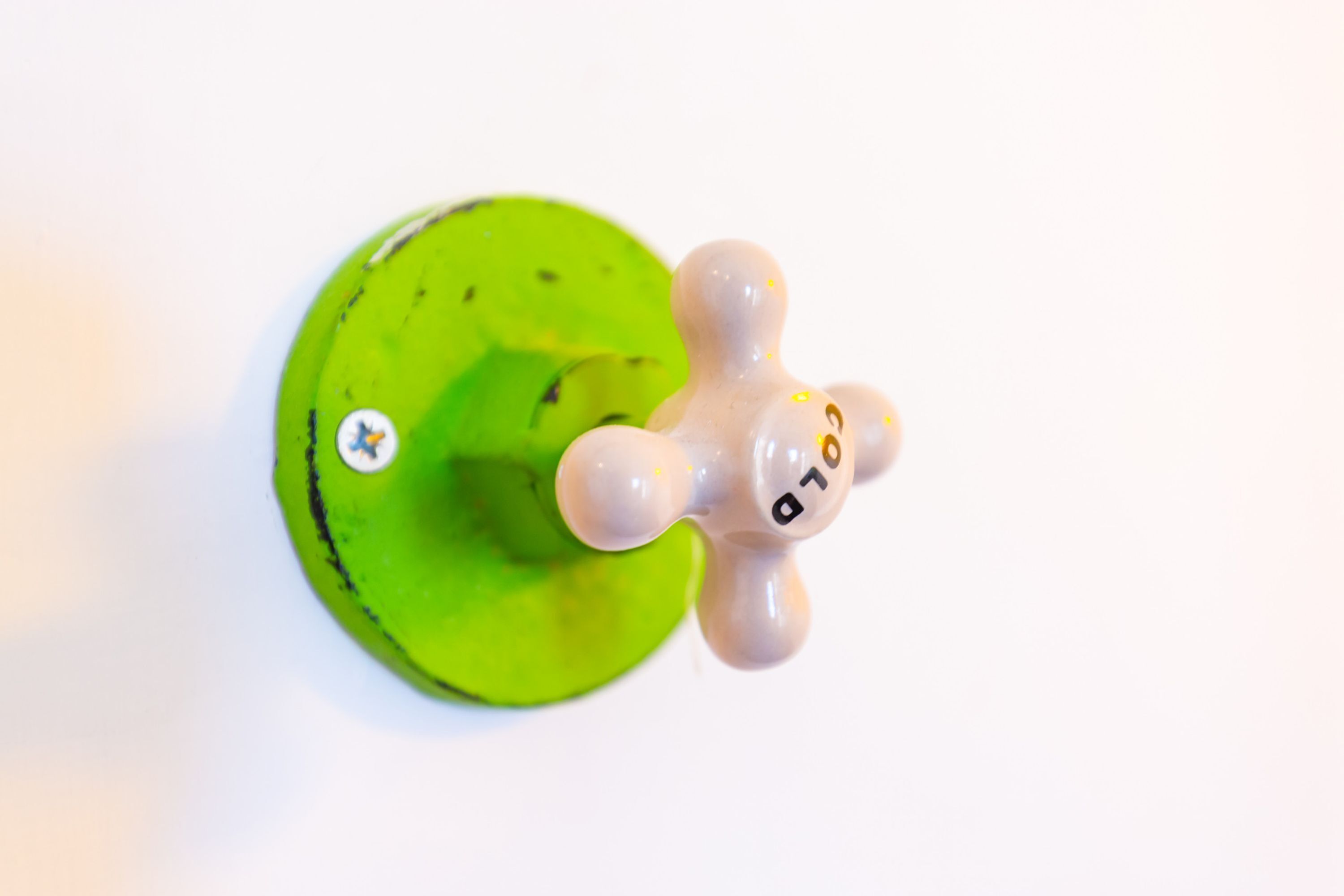A green circular object with a small white sticker and a beige figurine with numbers on it.