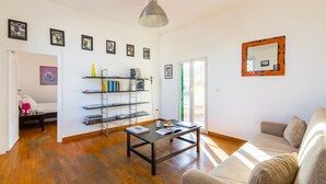 A living room with a sofa, a coffee table, a bookshelf, and a mirror on the wall. - Stylish in Spanish Quarter by Wonderful Italy (Naples)