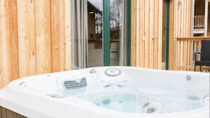 A hot tub in a wooden cabin with a glass door leading to a balcony. - Attractive Chalet With Whirlpool (Sankt Georgen am Kreischberg)