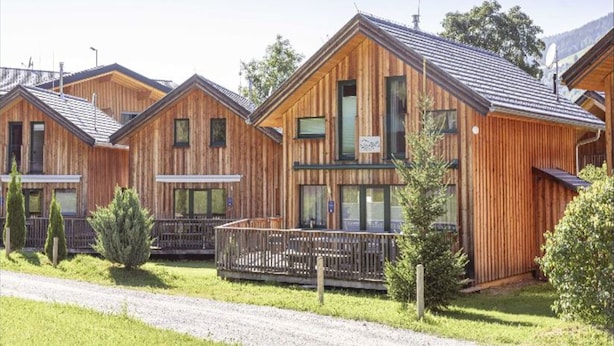 A row of wooden cabins with pitched roofs, each featuring a balcony and a small porch area. - Attractive Chalet With Whirlpool (Sankt Georgen am Kreischberg)