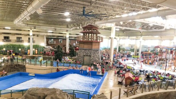 An indoor water park with multiple pools, a central water slide, and a lookout tower. - Ultimate Group Getaway: Sleeps 16, Hot Tub, Arcade, & 5 Min from Mall of America (Minneapolis)