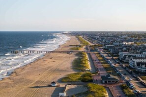 Une ville côtière dotée d’une plage, d’une jetée et d’une rangée de maisons le long du rivage.