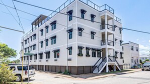 A multi-story building with a flat roof, large windows, and a central staircase.