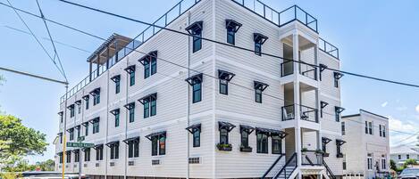 Un edificio de varios pisos con techo plano, ventanas grandes y una escalera central.