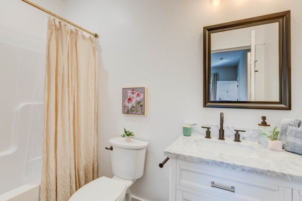 Un baño con inodoro, lavabo y cortina de ducha.