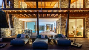 A modern outdoor seating area with cushioned benches and a pool in the background. - Ponte de Lima Chalet Pool & Golf (Feitosa)