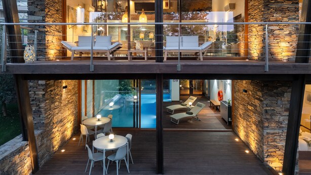 A modern house with a glass balcony, stone walls, and a pool area. - Ponte de Lima Chalet Pool & Golf (Feitosa)