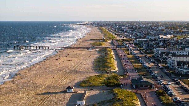 Un pueblo costero con playa, muelle y edificios residenciales.