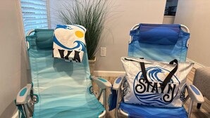 Dos sillas de hospital con fundas de estampado de olas, una con una toalla y la otra con un bolso.