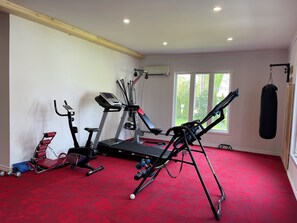Un gimnasio con cintas de correr, elípticas y un saco de boxeo.