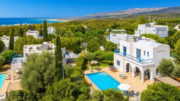 A resort with a swimming pool, multiple buildings, and a view of the sea. - Villa Artemis - Four Bedroom Villa, Sleeps 8 (Peyia)
