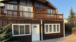 A two-story house with a balcony, a garage, and a front door.