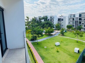 Una zona residencial con edificios modernos, un césped cuidado y una piscina.