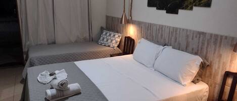 Habitación de hotel con dos camas, cabecero de madera, lámpara de pared y un cuadro.