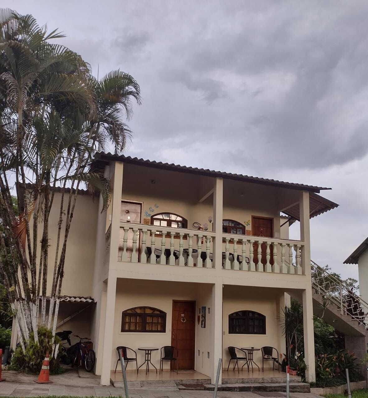 Un edificio de dos pisos con un balcón, una puerta y una escalera.