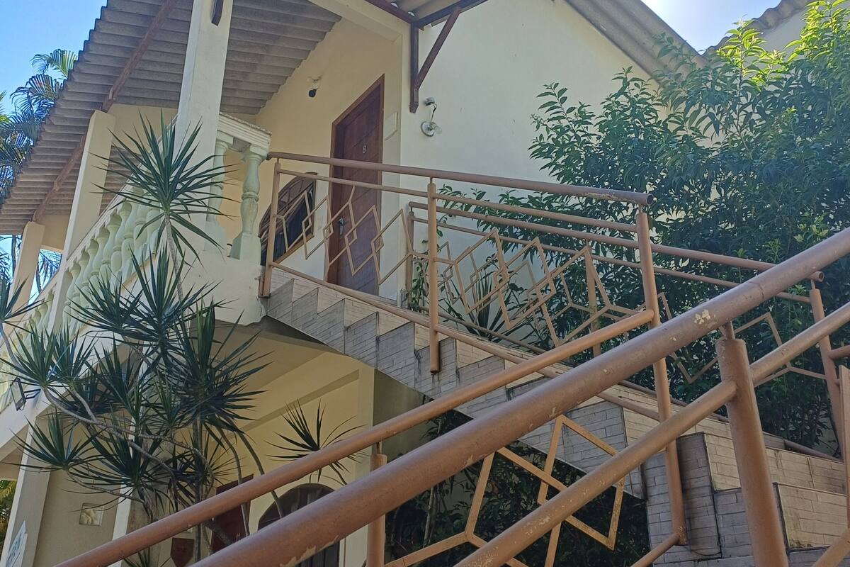A multi-story building with a staircase, a balcony, and a door.