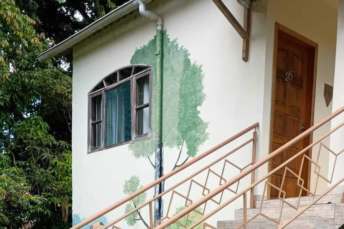 A staircase with geometric metal railings leading to a building with a mural.
