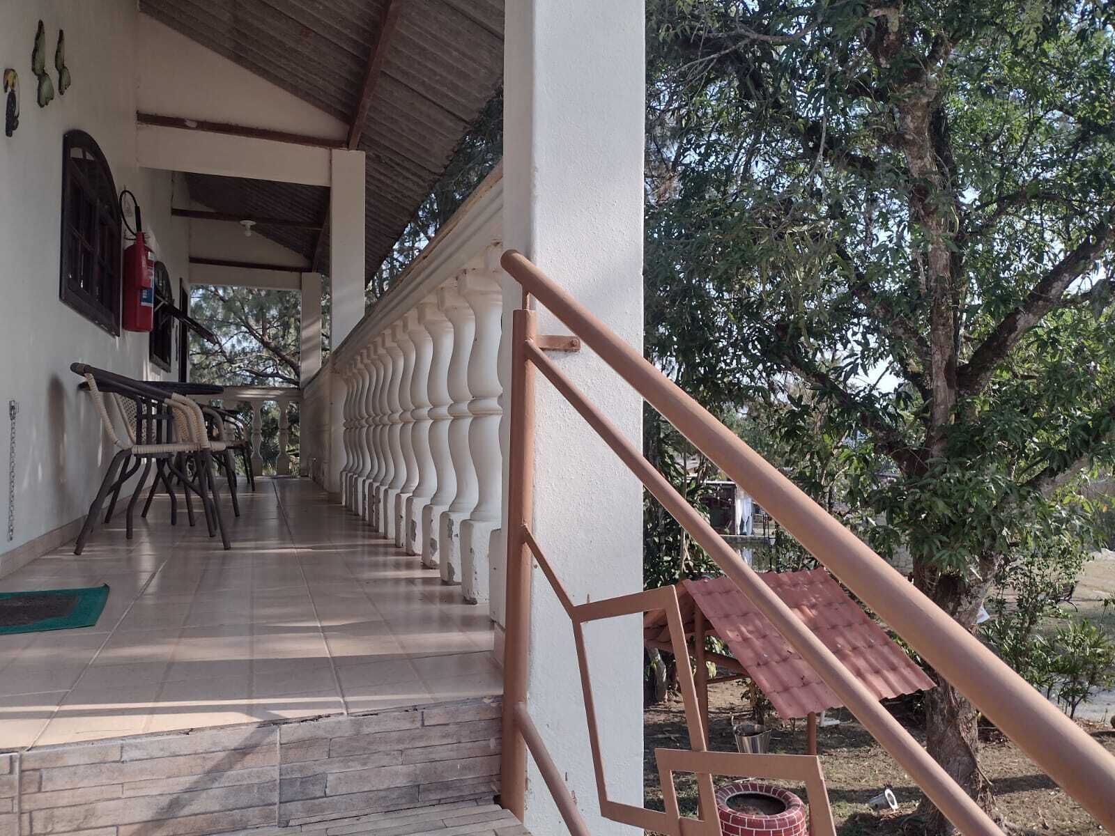 Un espace extérieur abrité, doté d’un escalier, d’un extincteur et d’un four en briques.