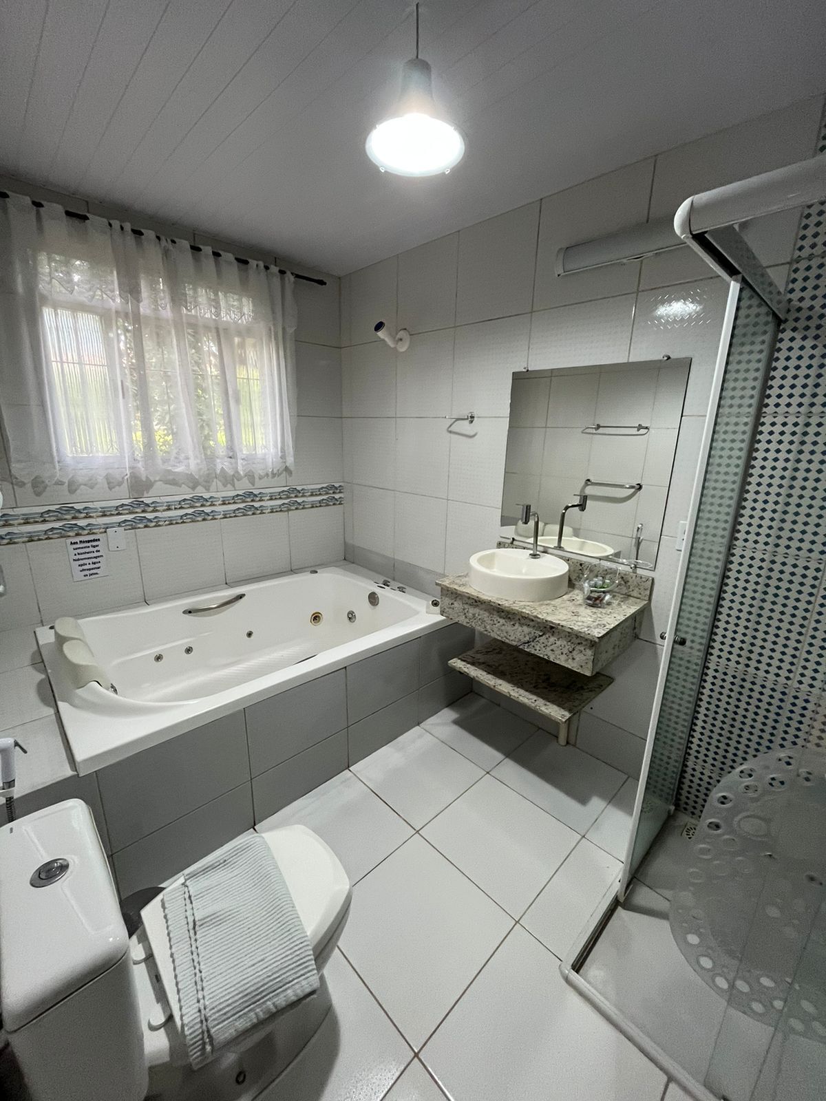 A bathroom with a bathtub, sink, toilet, and shower.