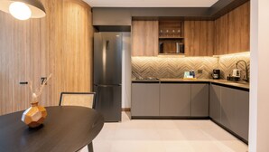 A modern kitchen with wooden cabinets, a built-in microwave, and a stainless steel refrigerator.