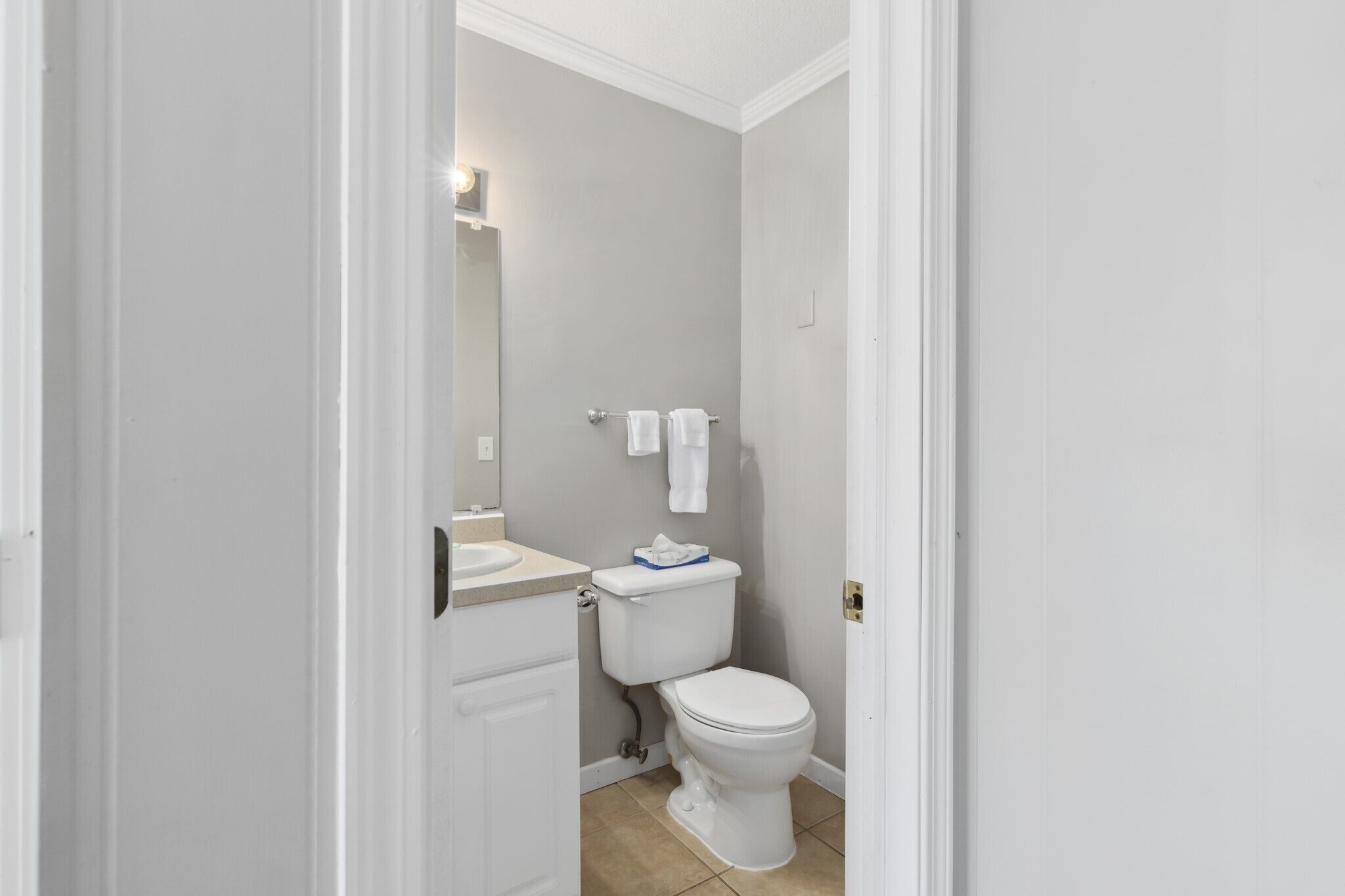 Een kleine badkamer met toilet, wastafel en spiegel.